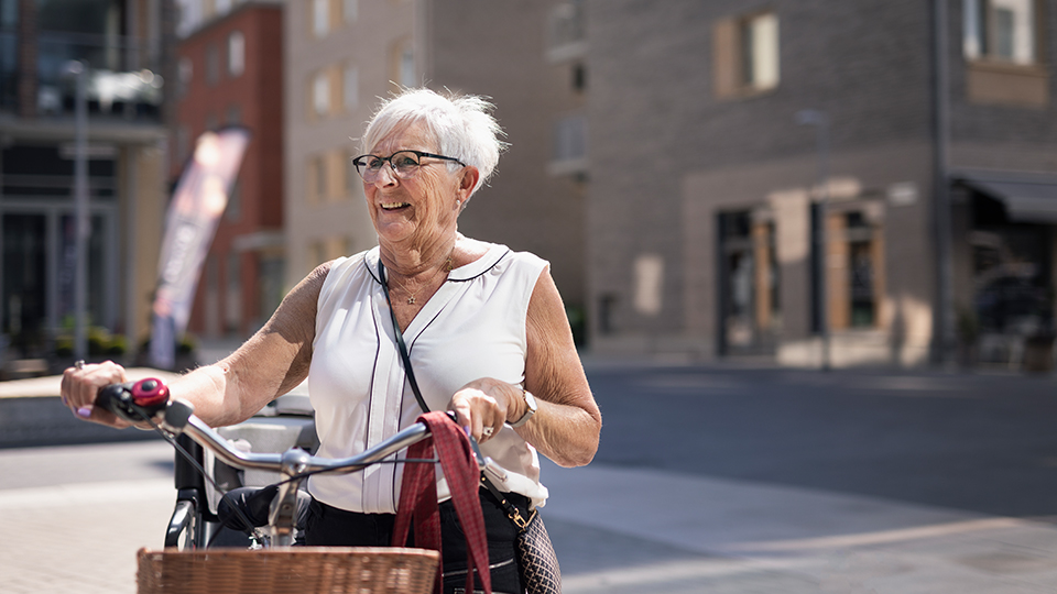 Bild på äldre kvinna med cykel