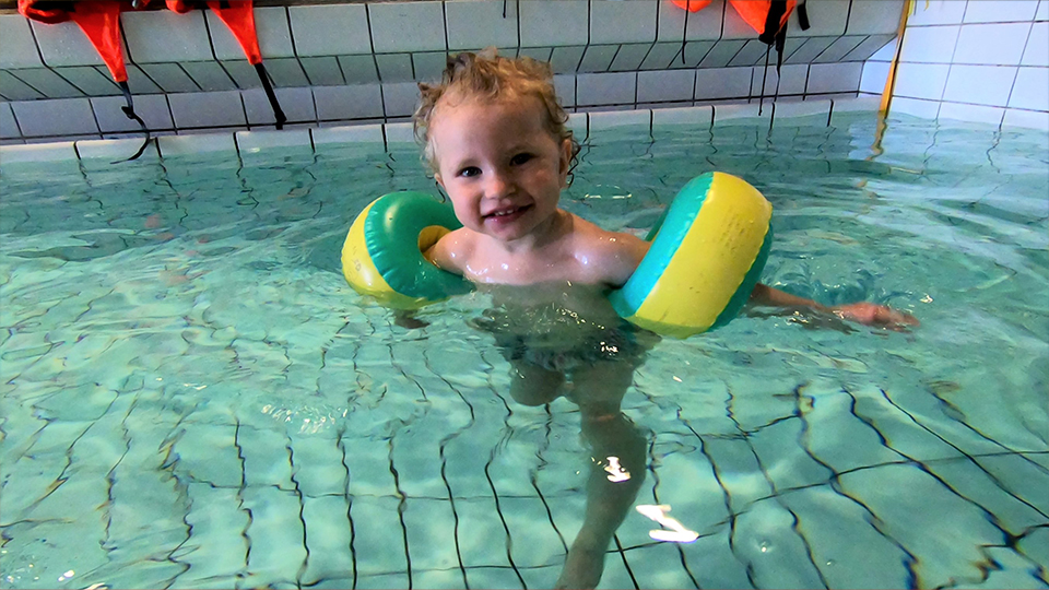 Ett barn som badar med simpuffar